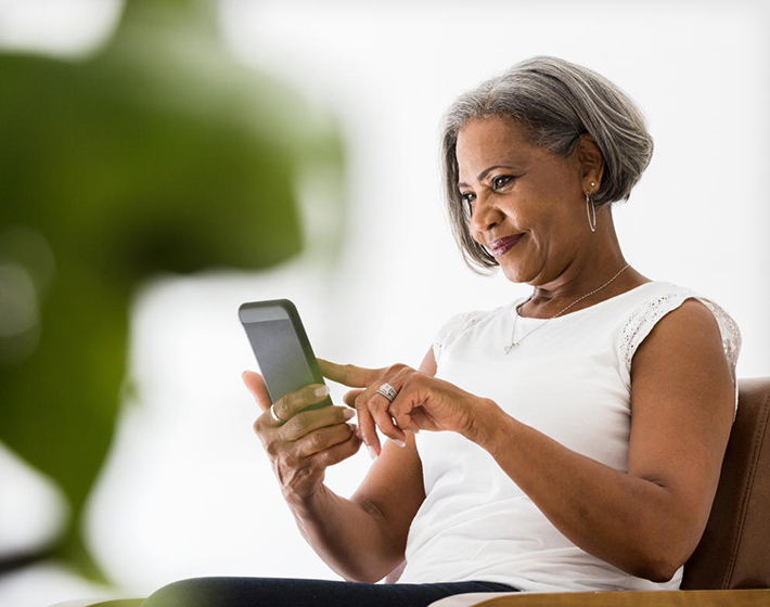 senior Black woman takes a call on her smartphone