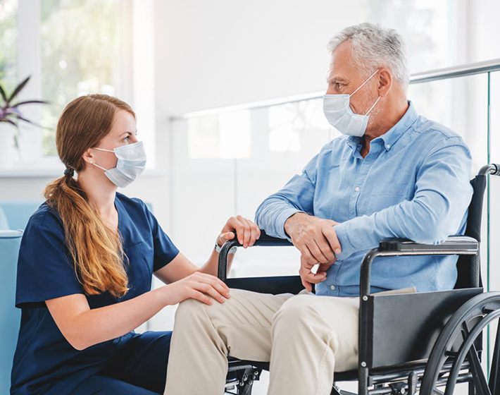 young nurse speaks to a senior living resident