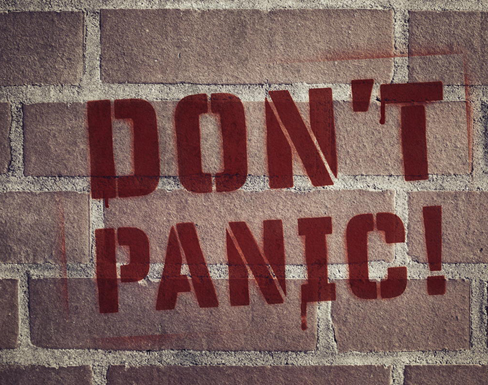 "Don't Panic!" Stencil Spray-Painted on Brick Wall