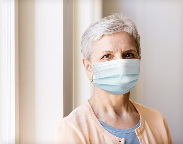 senior woman wears a medical face mask