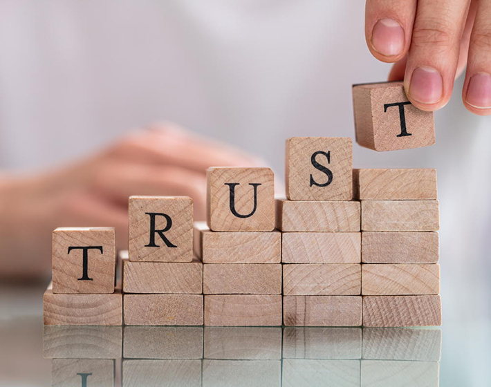 wood tiles with letters spells out trust