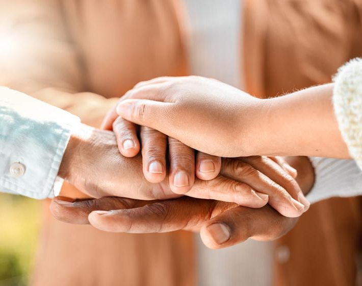 family members place their hands on top of one another to express gratitude for one another