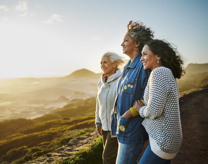 3 older women having a real conversation as they view the scenic desert on a group trip