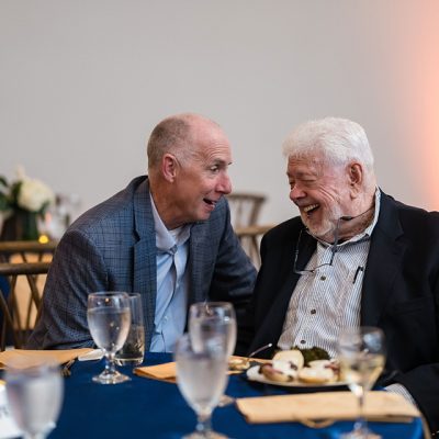 An older Black woman claps as part of a Jazz audience