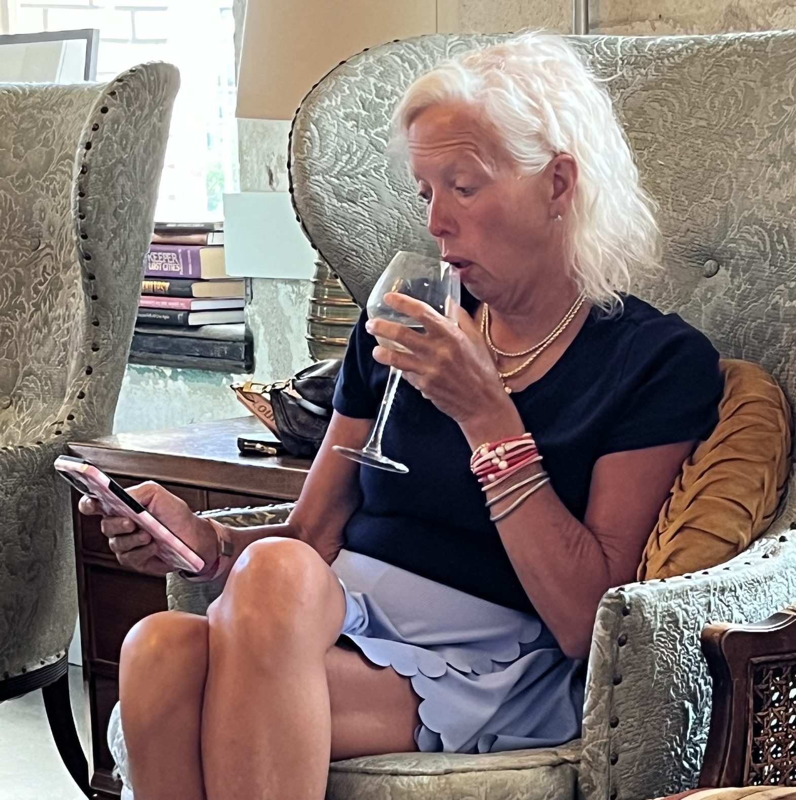 Angela enjoys a glass of Champagne as she checks her phone after our spa day