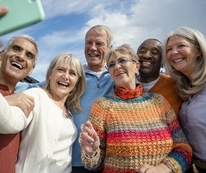 a group of six Baby Boomers take an outdoor selfie